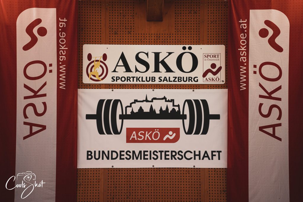 Mehrere ASKÖ‑Plakate und Banner schmücken den Raum der Bundesmeisterschaften und verleihen dem Bewerb ein offizielles Ambiente.